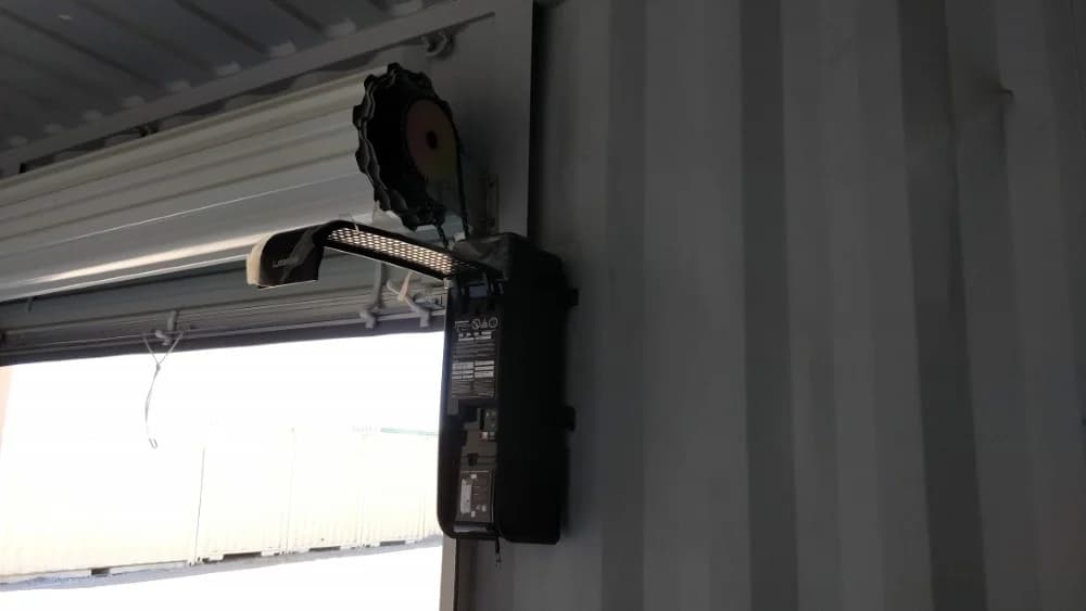 A rolled-up door with the control unit and motor viewed from the inside of a shipping container