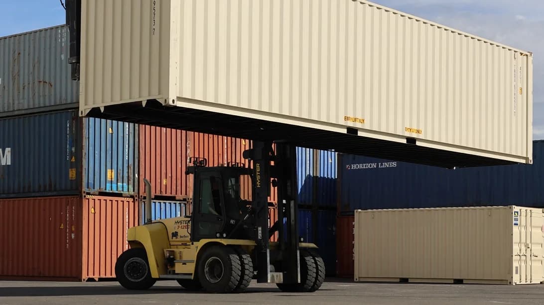 Forklift lifting shipping container