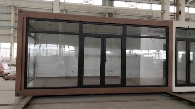 Glass-walled container unit with black frame and brown exterior.
