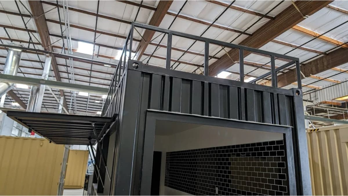 Shipping container cafe with rooftop deck and raised service window