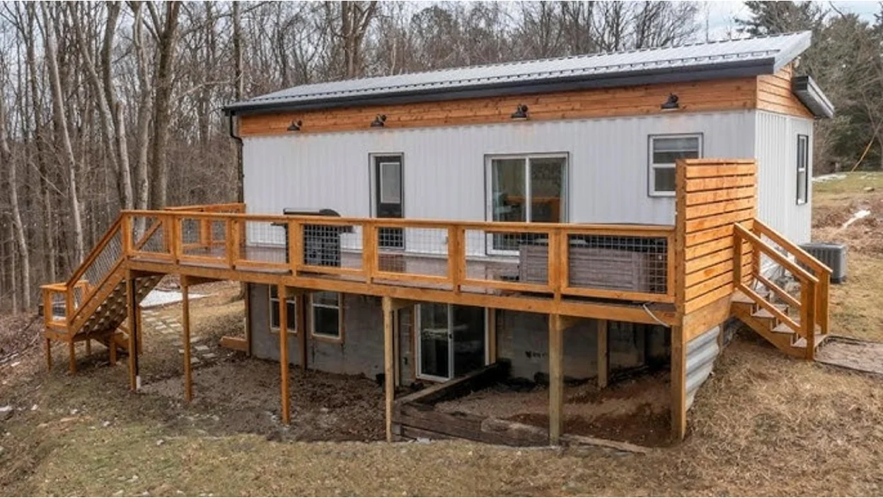 A shipping container with a basement in the woods