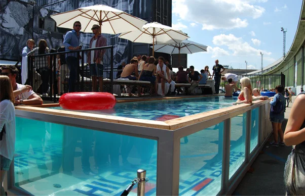 Image of a shipping container pool with people in it