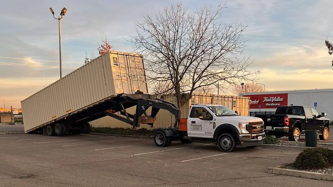 Tilt-bed truck with trailer container delivery